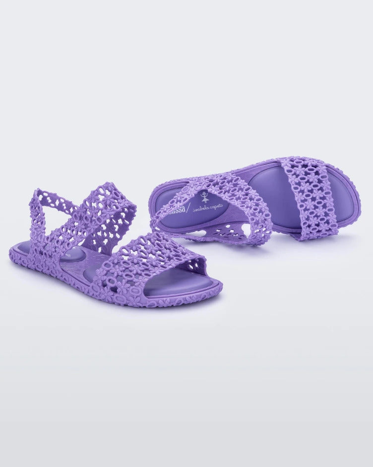 Angled view of a pair of purple Melissa Panc Sandals.