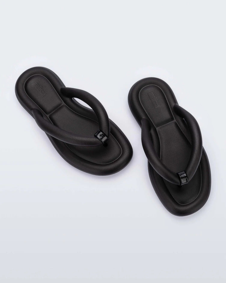 Top view of a pair of black Melissa Free Flip Flops with puffer-like straps.