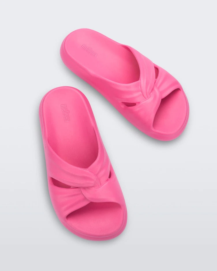 A top view of a pair of pink Melissa Free Slides with puffer-like straps.