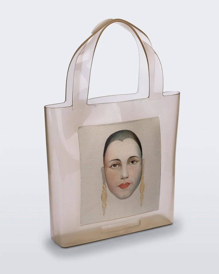 An Adult Melissa Canvas + Tarsila Do Amaral Bag with a picture of a woman's face on it.
