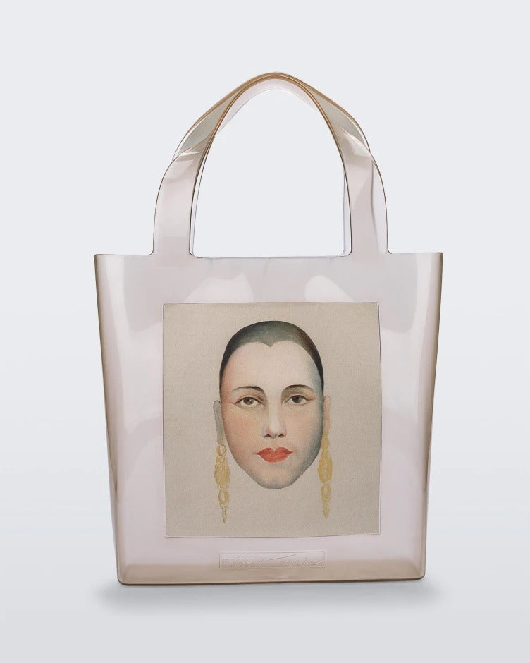 An Adult Melissa Canvas + Tarsila Do Amaral Bag with a picture of a woman's face on it.