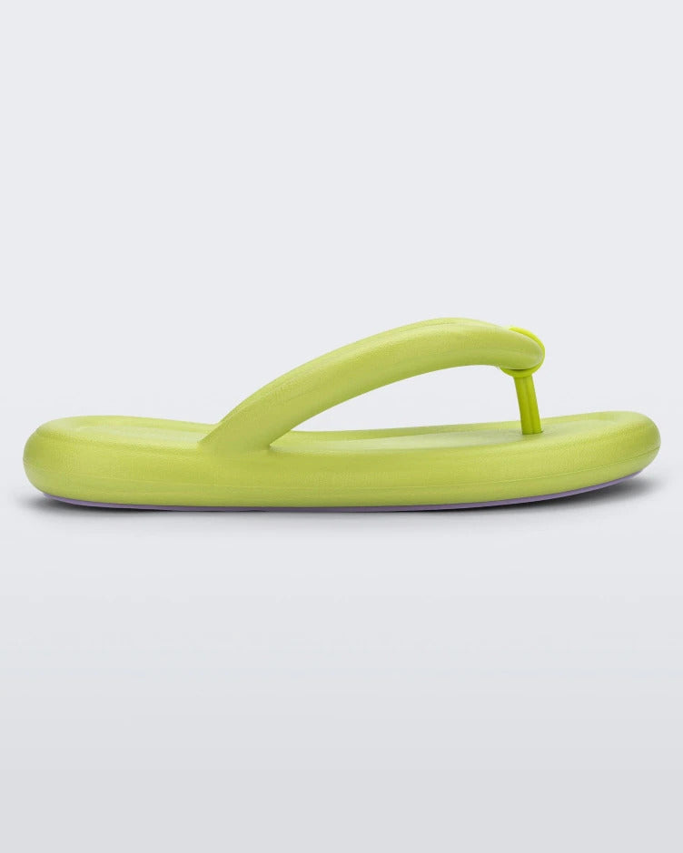 Side view of a lime green Melissa Free Flip Flop with puffer-like straps.