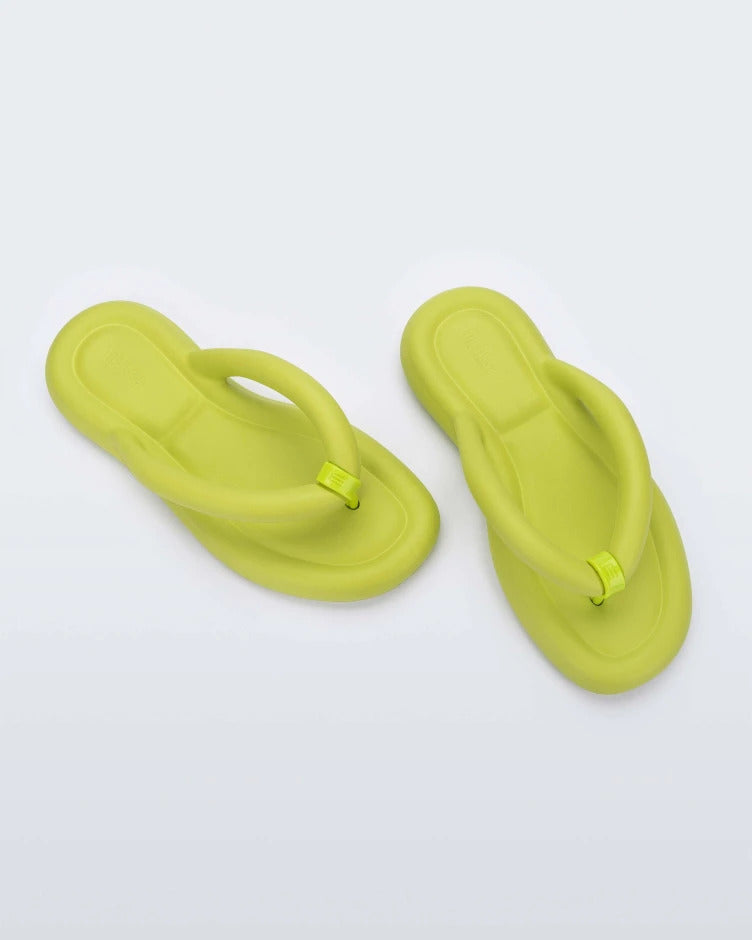 Top view of a pair of lime green Melissa Free Flip Flops with puffer-like straps.