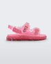 Side view of a pink Mini Melissa Wide Sandal with a clear pink base with a splatter paint detail, two buckles at the top, a velcro ankle strap and a pink insole.