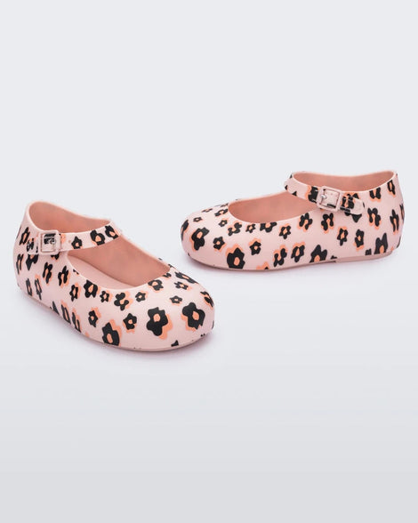 Side view of a pair of Mini Melissa beige / black Dora flats with black and orange flower print.
