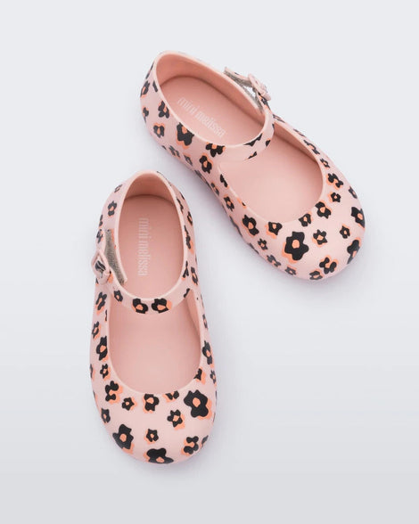 Top view of a pair of Mini Melissa beige / black Dora flats with black and orange flower print.