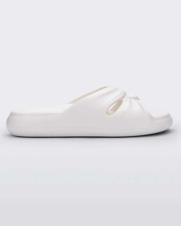 Side view of a white Melissa Free Slide with a twist front detail.