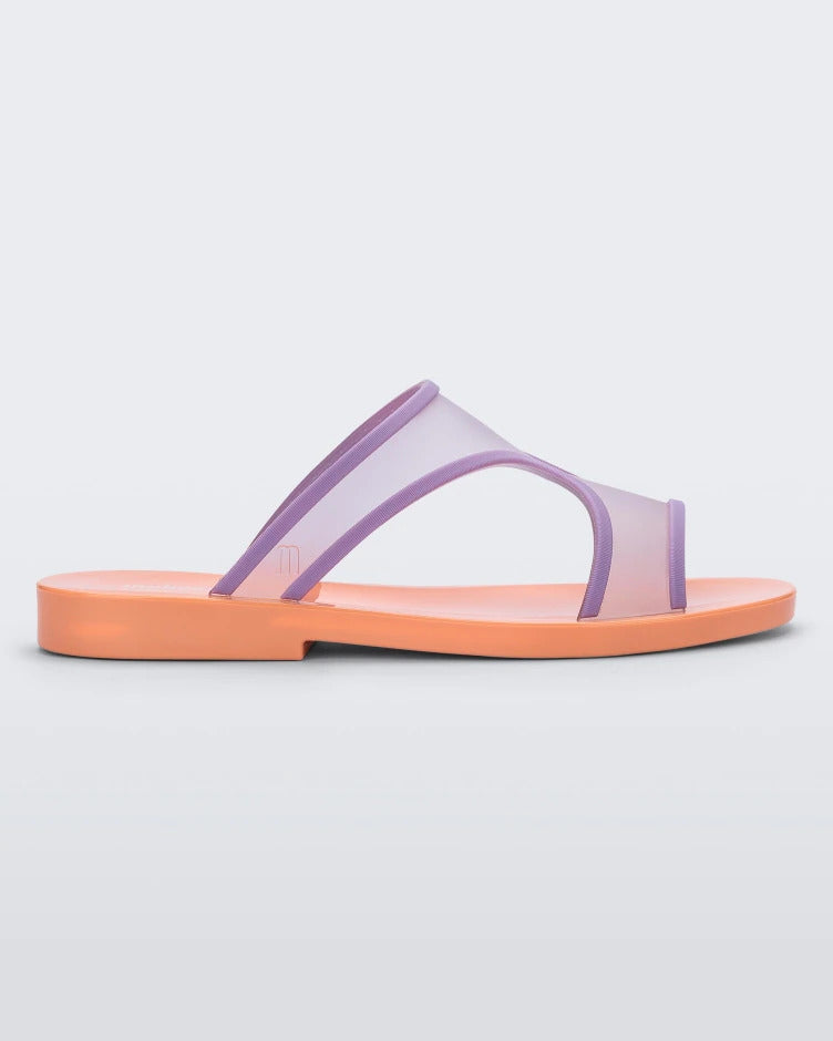 Side view of a orange/lilac Melissa Bikini Slide with a two transparent purple straps conjoining in the middle and an orange insole.