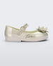 Side view of a Metallic White/Green Mini Melissa Sweet Love Princess flat with a metallic white base with Tiana in script on the side, a top strap, a flower detail on the toe and a drawing of Tiana of The Princess and The Frog on the insole.