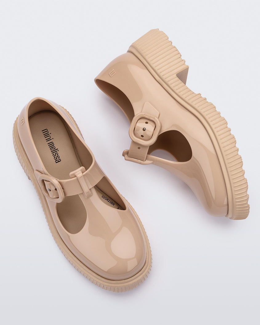 Top and side view of a pair of beige Mini Melissa Jackie loafers with two cut outs and a buckle detail strap.