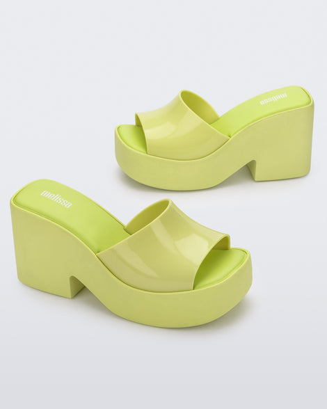 Angled view of a pair of Melissa Posh platform slides in Yellow