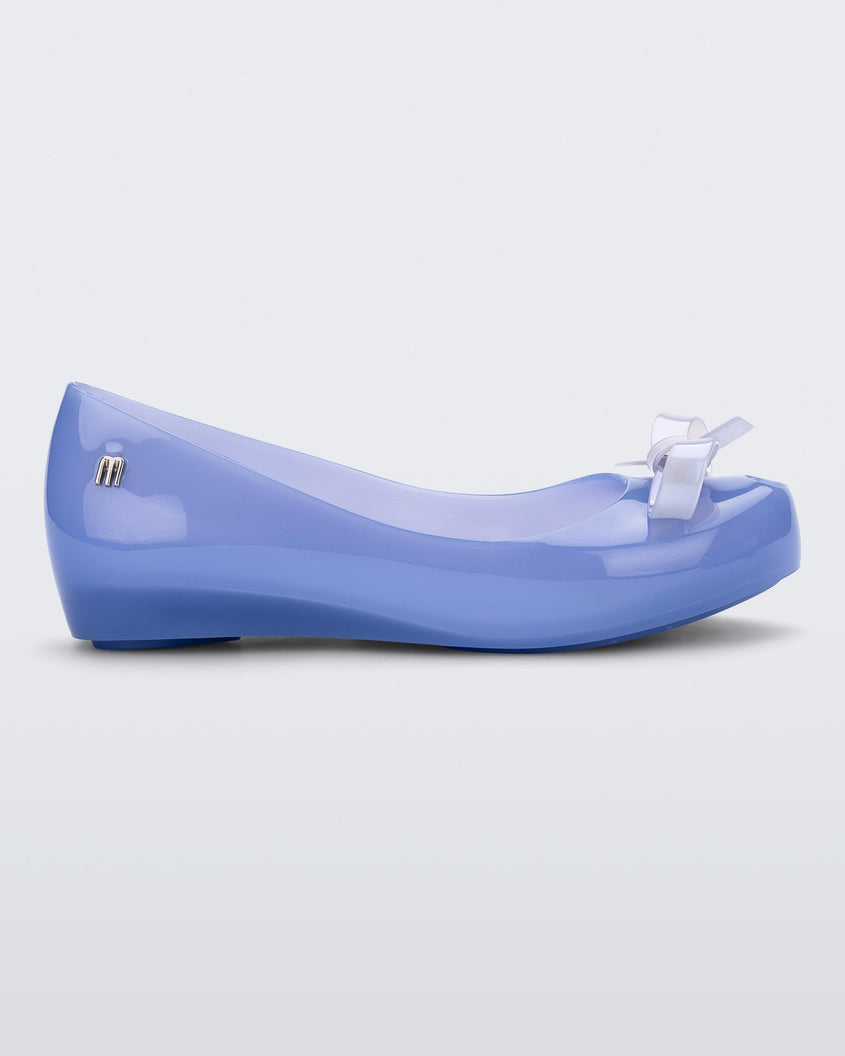 Side view of a blue Mini Melissa Ultragirl Bow flat with a blue base and a white bow.