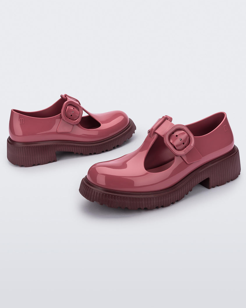 Side view of a pair of Burgundy Mini Melissa Jackie loafers with a Burgundy base, two cut outs, a Burgundy buckle detail strap and brown sole.