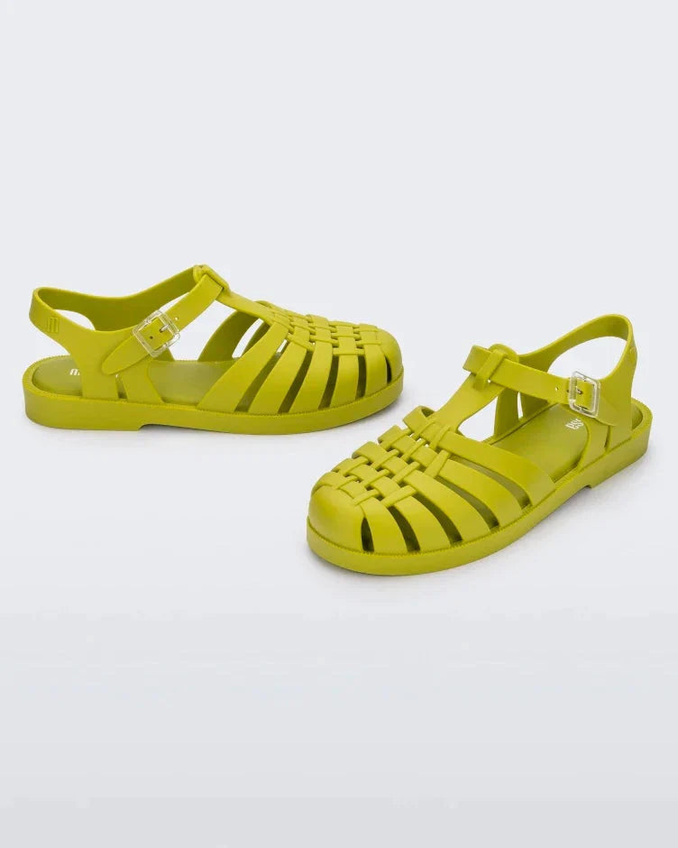An angled front and side view of a pair of moss green Melissa Possession sandals with several straps and a closed toe front.