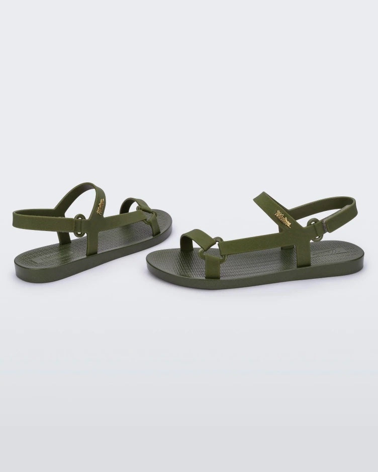 Side view of a pair of green metallic Melissa Sun Downtown sandals with a front and ankle strap joined together by a vertical strap and a triangle buckle.