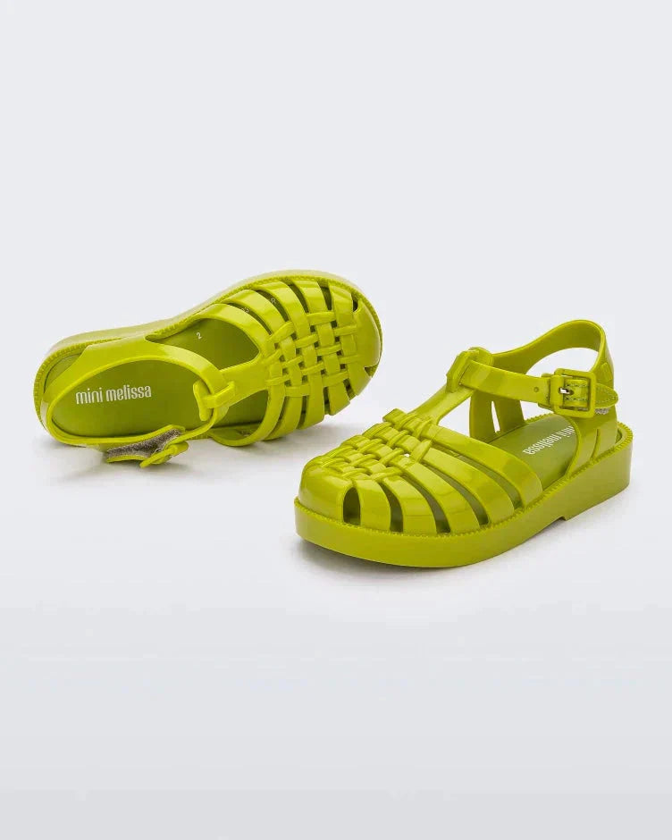A front and top view of a pair of green Mini Melissa Possession sandals with several straps and a green base.