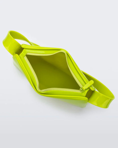 A top view showing the zipper opening of a neon green Melissa Baguete handbag.