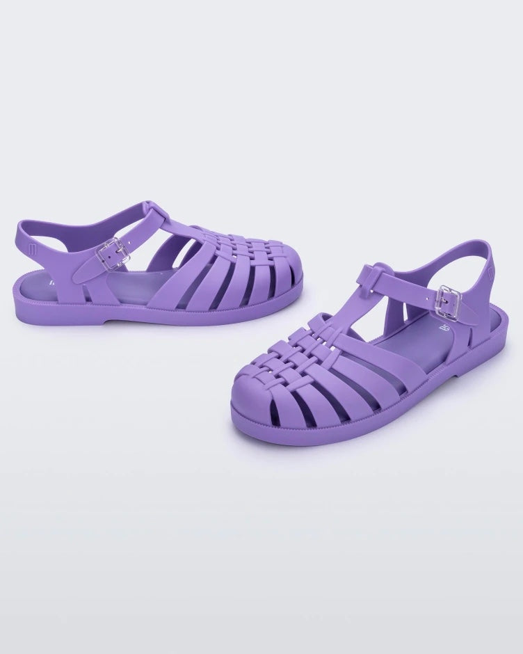 An angled front and side view of a pair of lilac Melissa Possession sandals with several straps and a closed toe front.