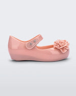 Side view of a light pink Mini Melissa Ultragirl Garden flat with a top strap and two rose details on the toe.