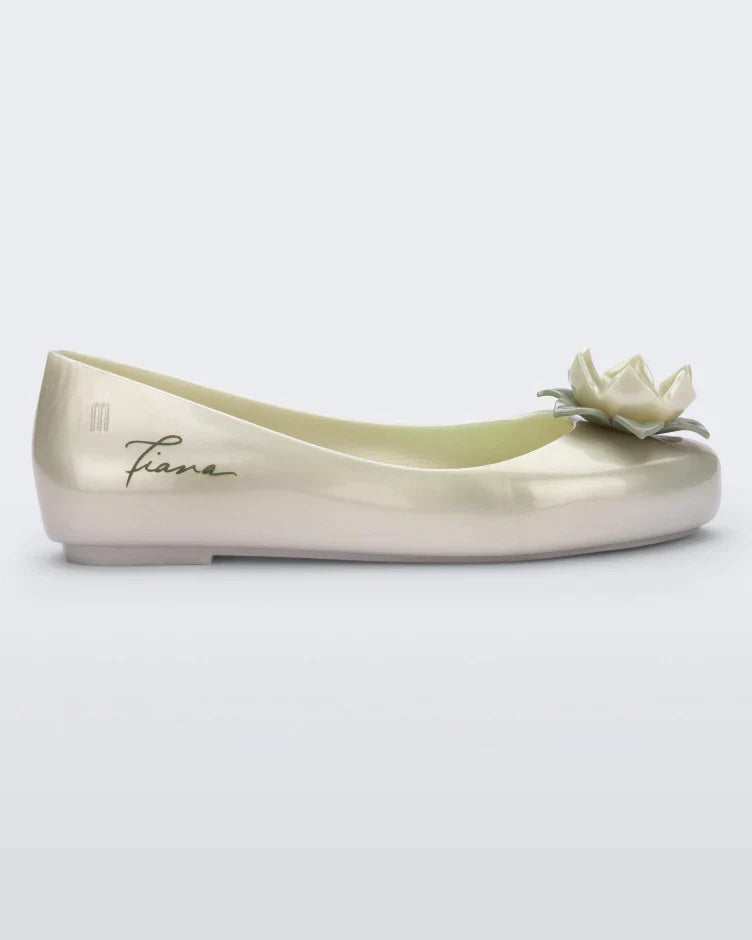 Side view of a green Mini Melissa Sweet Love Princess flat, with a pearly green base, Tiana in script on the side, a flower detail on the toe, and a drawing of Tiana of The Princess and the Frog on the sole.