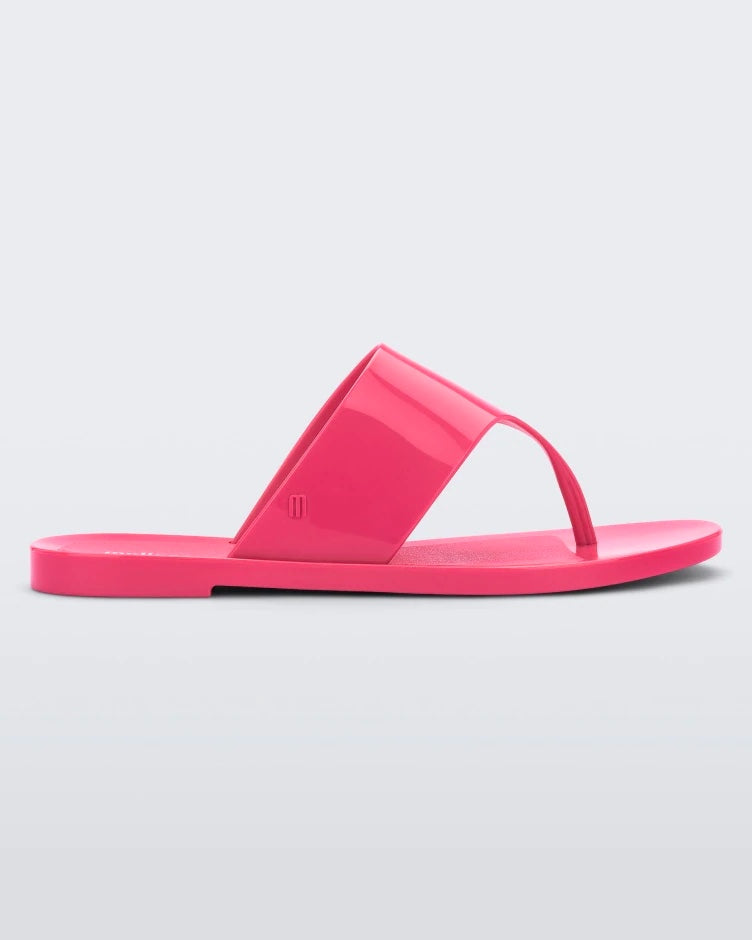 Side view of a pink Melissa Essential Chic Flip Flop with a wide upper strap.