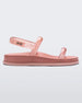 Side view of a pink/clear pink Melissa Soft Wave Sandal with a pink sole, two front clear pink straps and a clear pink ankle strap.