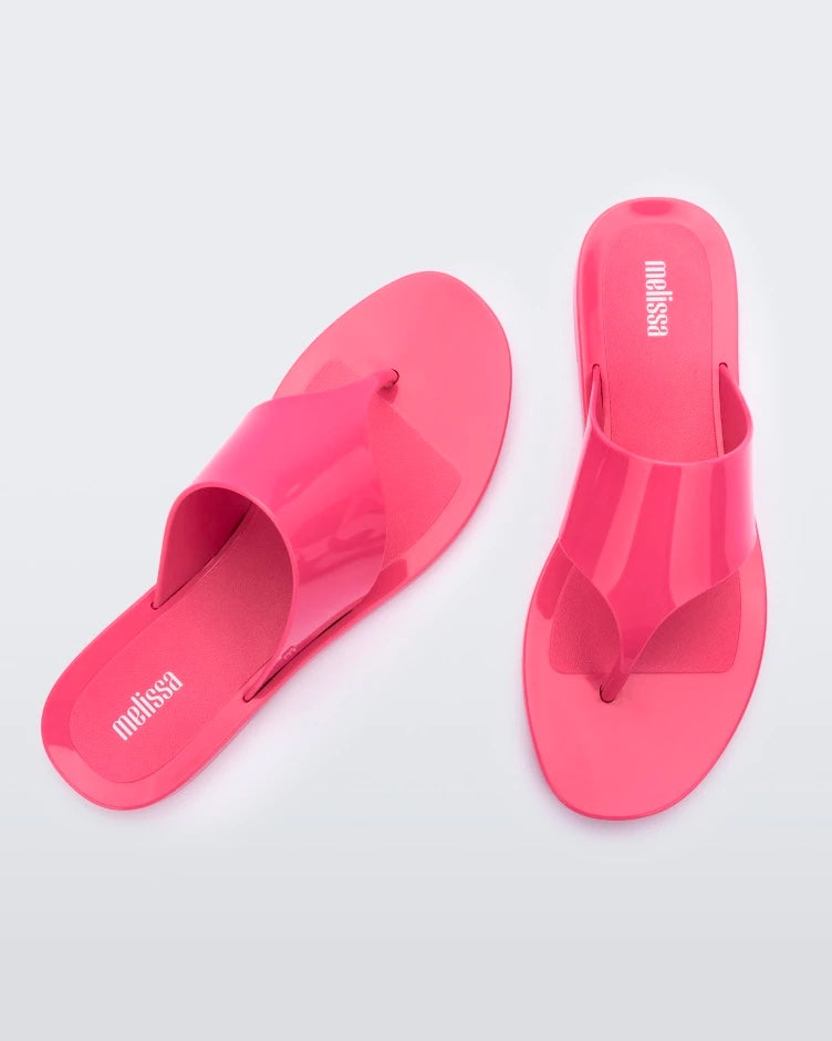 Top view of a pair of pink Melissa Essential Chic Flip Flops with a wide upper strap.