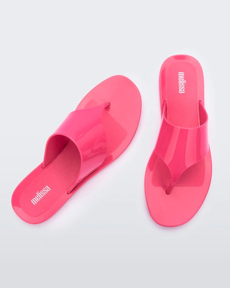Top view of a pair of pink Melissa Essential Chic Flip Flops with a wide upper strap.