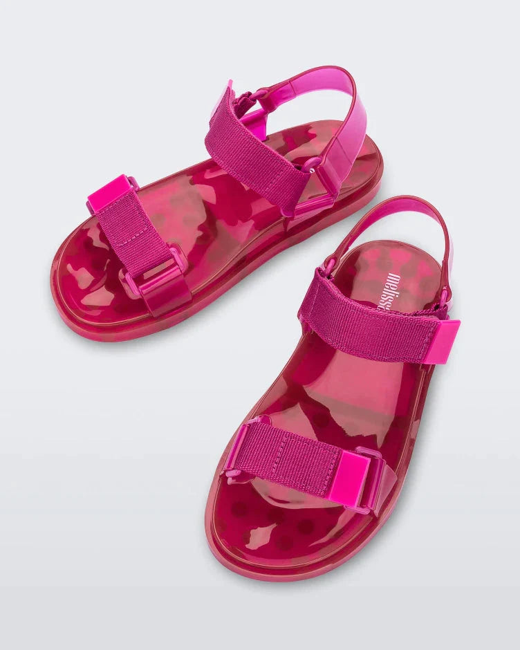 Top angled view of a pair of Melissa Wide Papete sandals in pink with velcro ankle and front straps.