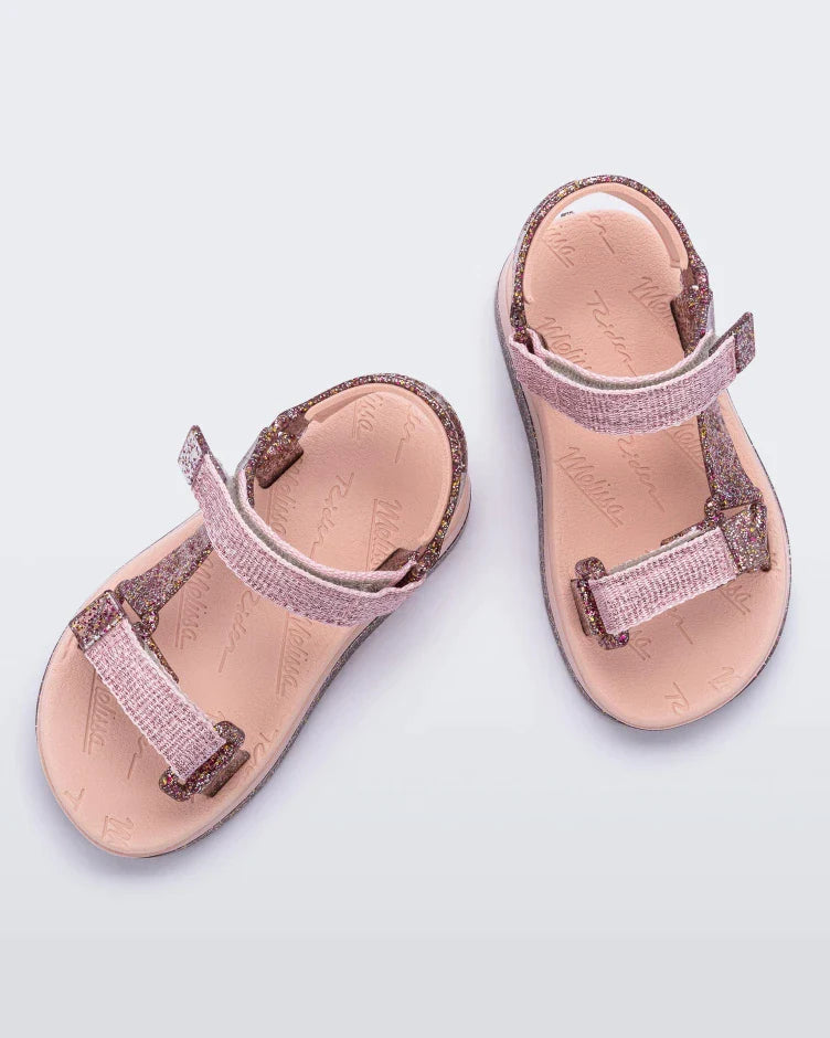 Top view of a pair of pink and glitter Mini Melissa Papete sandals.