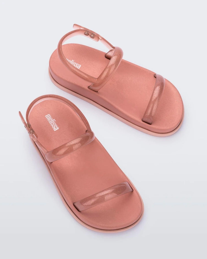 Top view of a pair of pink/clear pink Melissa Soft Wave Sandals with a pink sole, two front clear pink straps and a clear pink ankle strap.