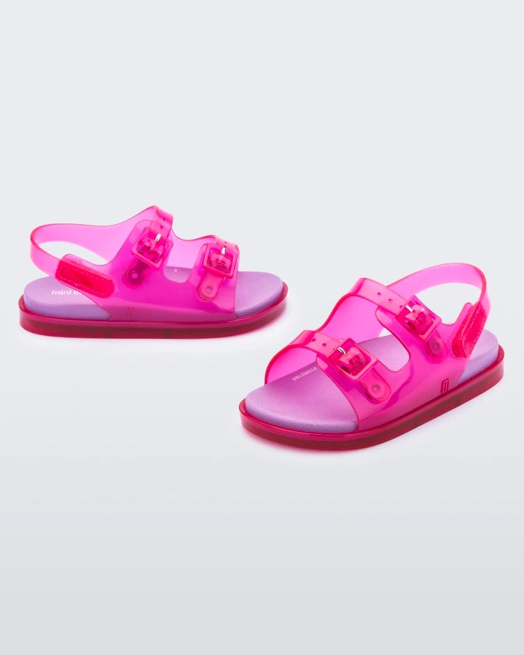 A front and top view of a pair of pink/lilac Mini Melissa Wide Sandals with a pink base, two pink buckles on top, a back ankle strap and a lilac insole.