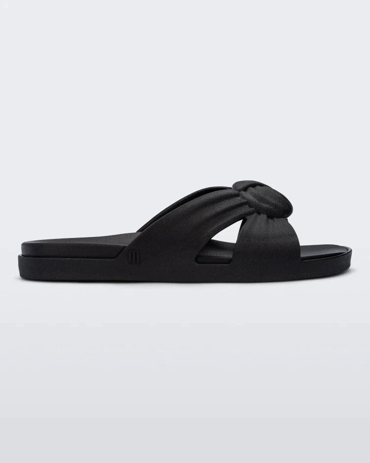 Side view of a black Melissa Plush slide with a twist front detail.