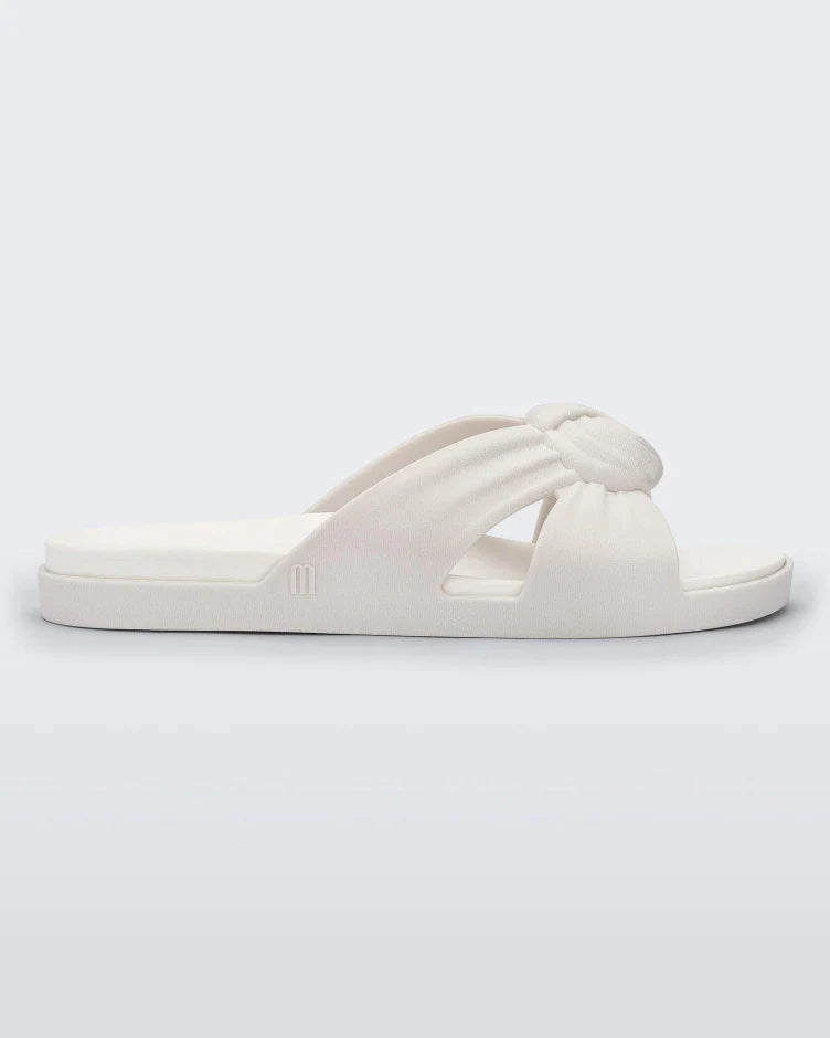 Side view of a white Melissa Plush slide with a twist front strap detail.