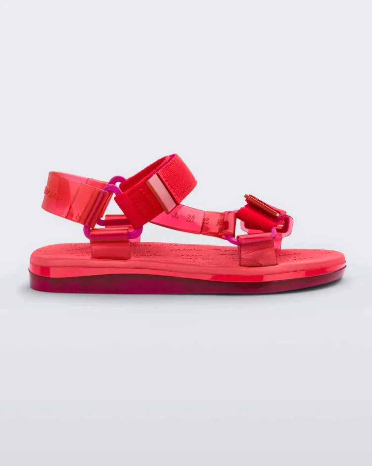 Side view of a pair of red Melissa Papete sandals.