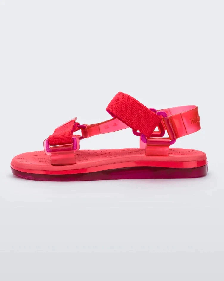 Side view of a pair of red Melissa Papete sandals.