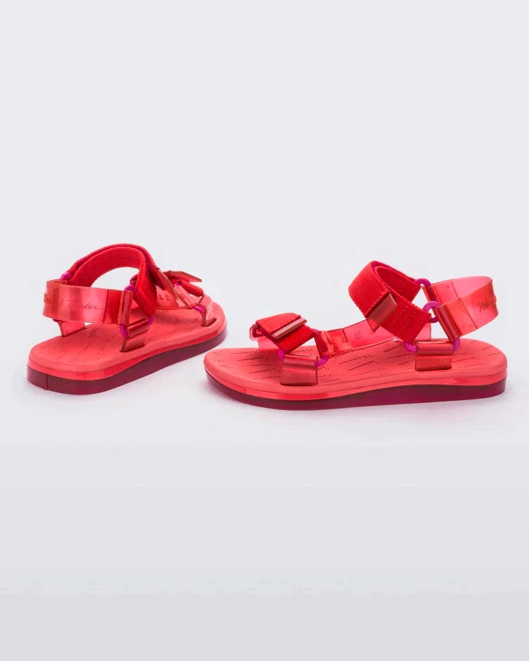 Side and back view of a pair of red Melissa Papete sandals.
