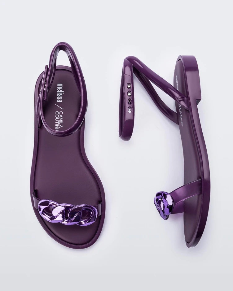 A top and side view of a pair of purple Melissa Dare sandals with a purple metal chain buckle.