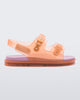 An outter side view of a Orange/Pink Mini Melissa Wide Sandal with a clear orange base, two buckles at the top, a velcro ankle strap and a pink insole.