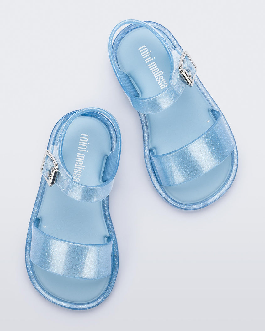 A top view of a pair of blue glitter Mini Melissa Mar Sandals with two straps and a metal buckle.