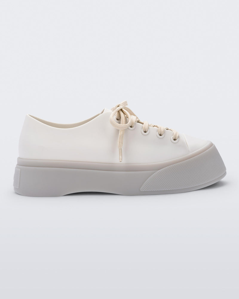 Side view of a beige Drive sneaker