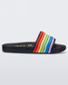 Side view of a black rainbow Melissa Rainbow Beach slide with a black base and a rainbow design on the front strap.