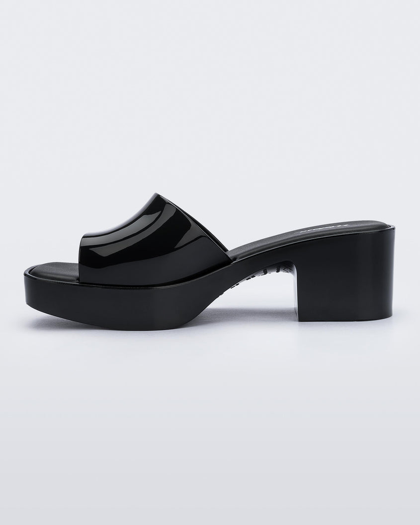 Inner side view of Melissa Shape slide in black, with a platform heel. 