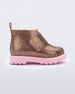 An outter side view of a pink/glitter multicolor Mini Melissa Chelsea boot with a multicolor glitter base, velcro front strap and a pink sole.