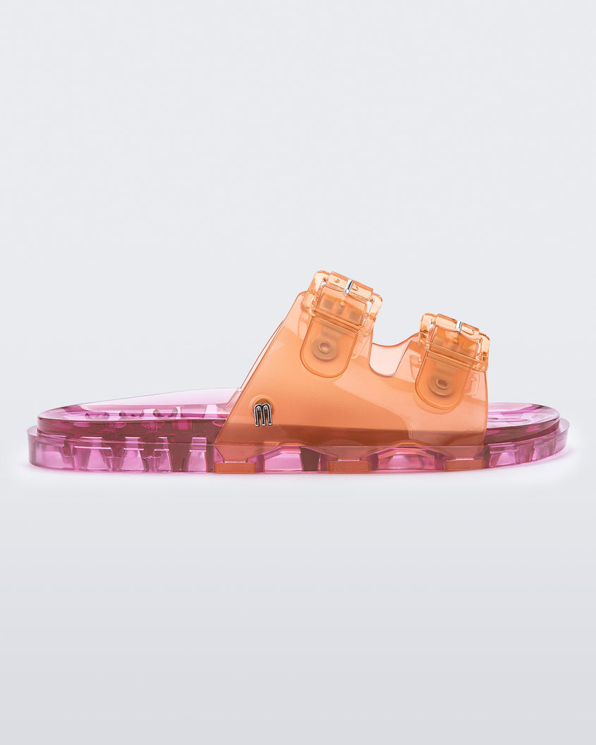 An inner side view of an orange/pink Mini Melissa Wide Slide with an an orange top with two silver buckles and a pink sole.
