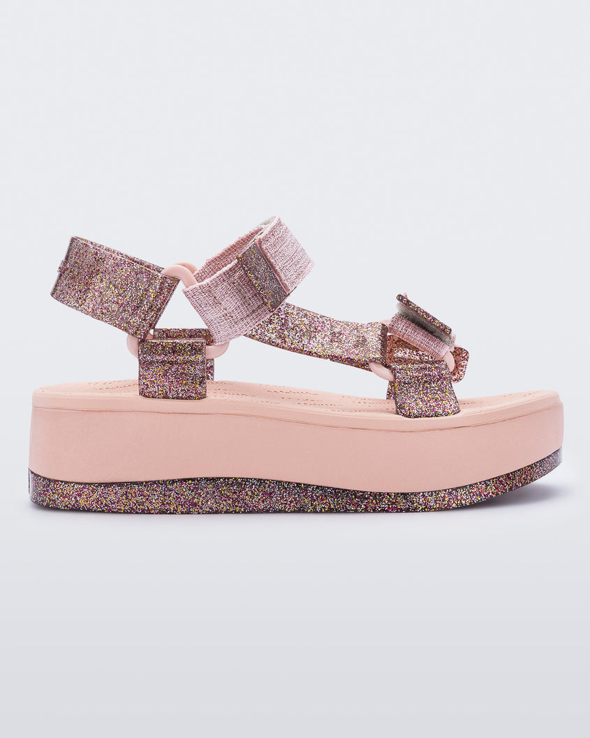 An outter side view of a pink Melissa Papete Platform sandal with glitter straps and a pink and glitter sole.