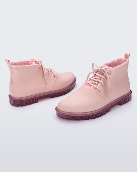 Side view of a pair of pink Melissa Fluffy Boots with laces and a rubber sole.