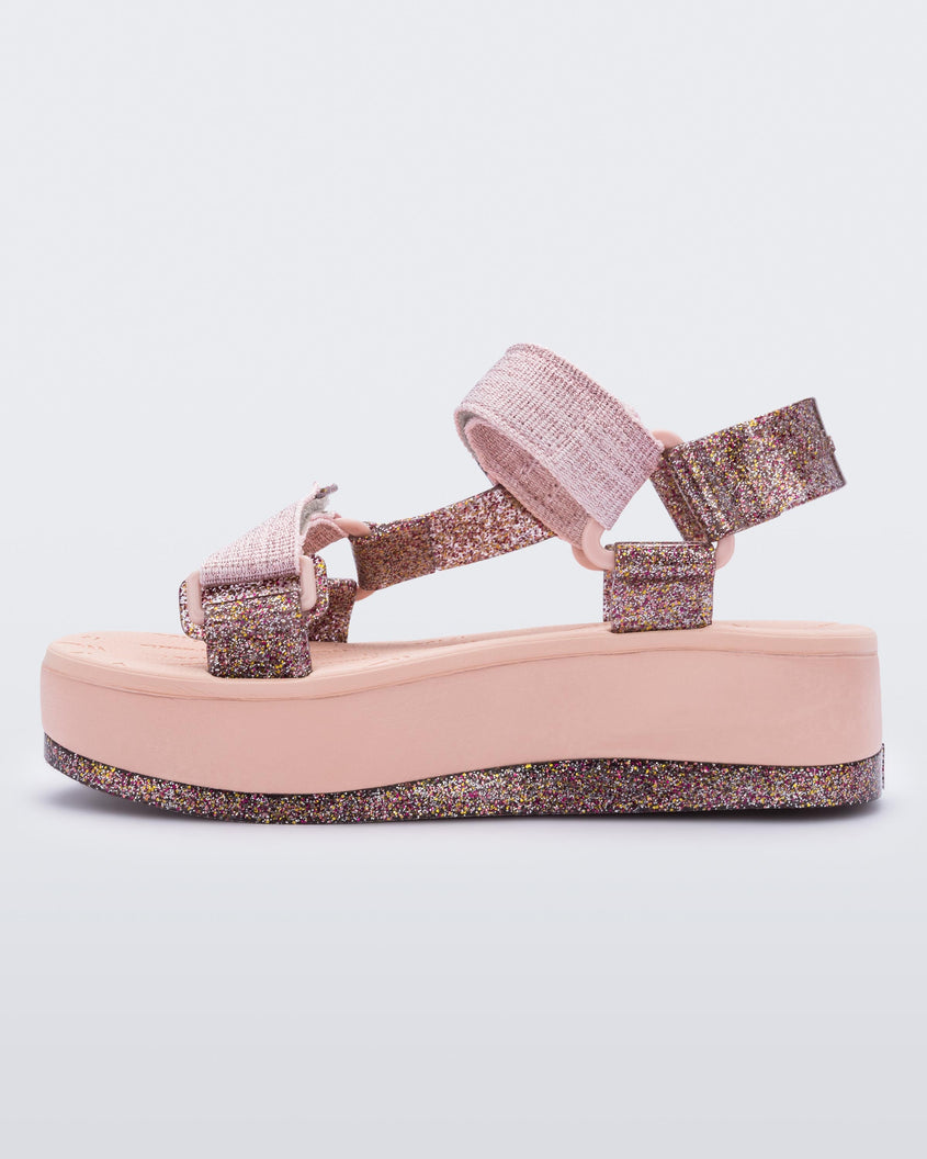 An inner side view of a pink Melissa Papete Platform sandal with glitter straps and a pink and glitter sole.