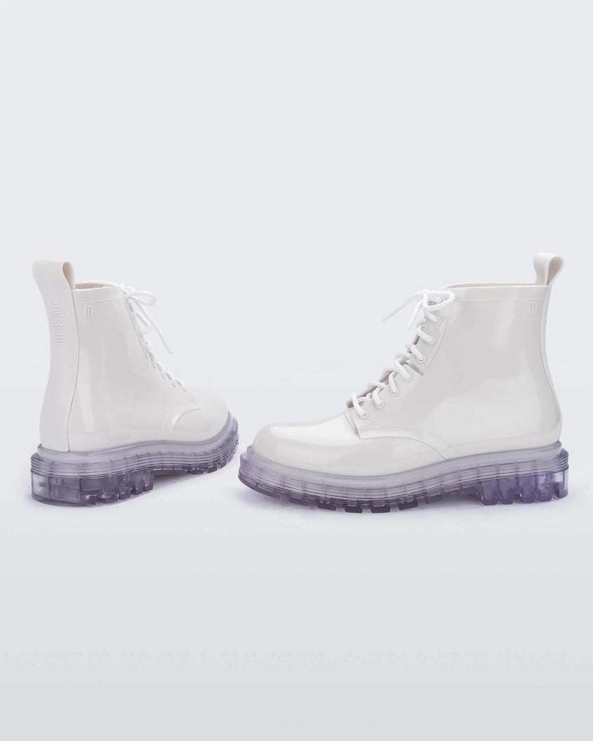 A back and side view of a pair of white/clear Melissa Coturno boots with a white base, laces and a clear sole.