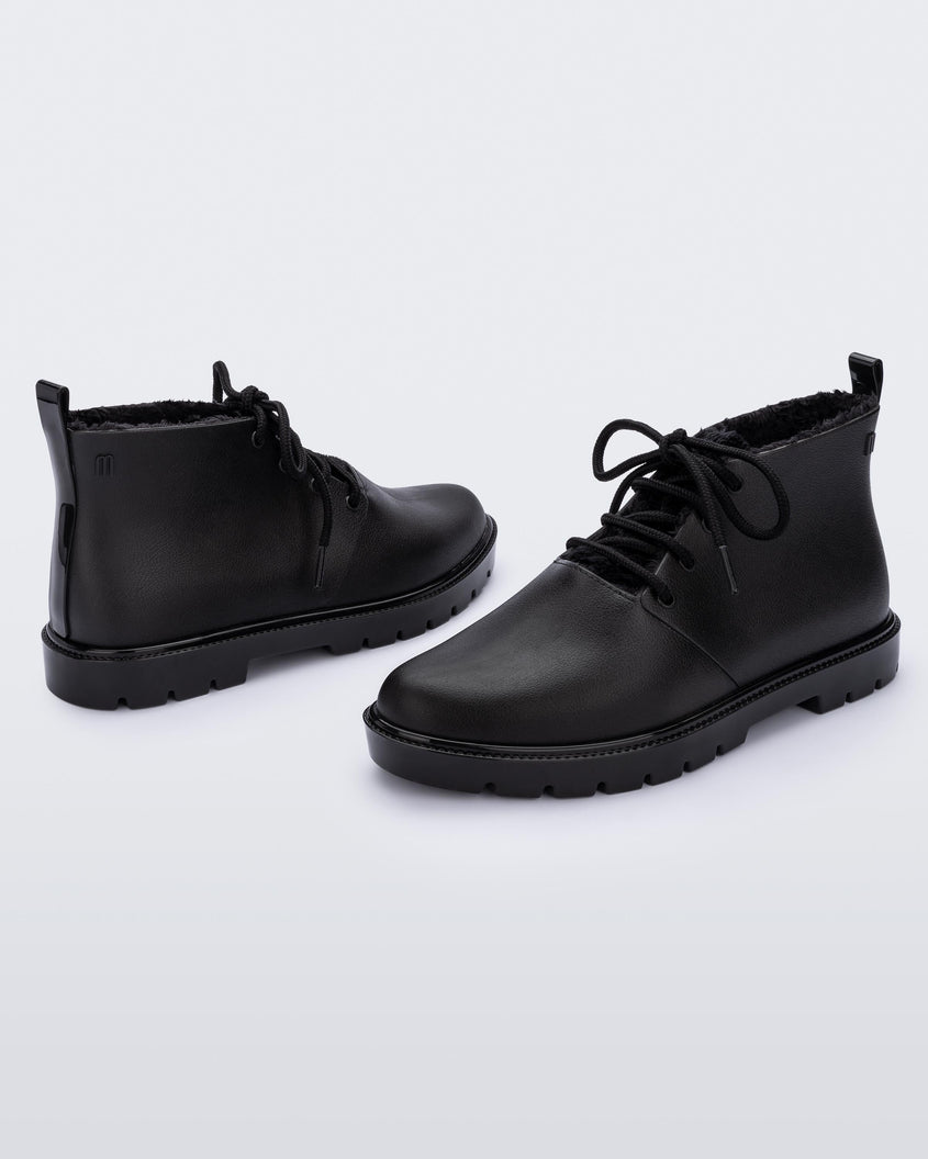 An inner and outter side view of a pair of black Melissa Fluffy Boots with laces and a rubber sole.